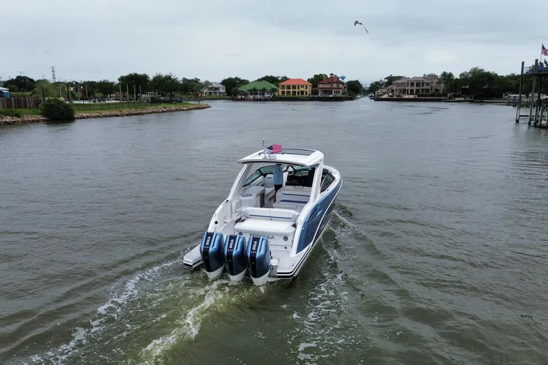 Slide: The Image of 2026 Formula 360 Crossover Bowrider OB cruising on a scenic waterway with triple outboard engines. - 21
