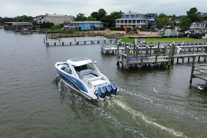 Slide: The Image of 2026 Formula 360 Crossover Bowrider OB cruising near docks on a scenic waterfront. - 25