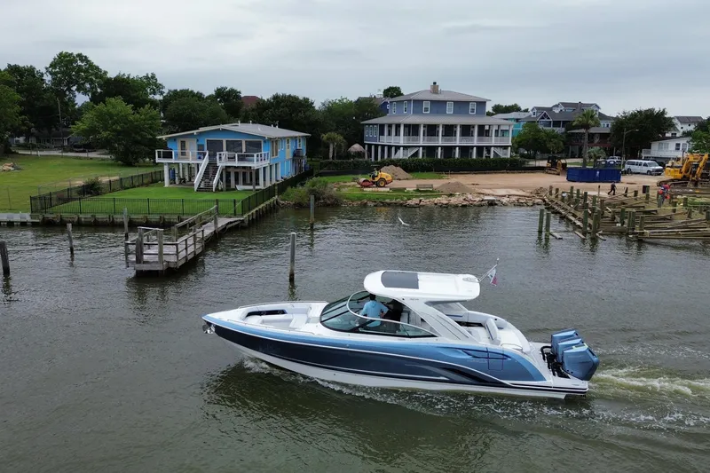 Slide: The Image of 2026 Formula 360 Crossover Bowrider OB cruising near waterfront homes. - 26