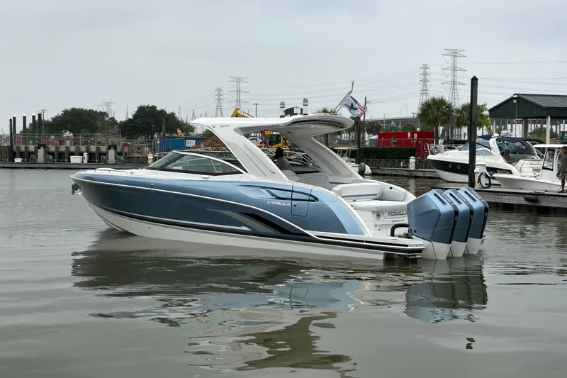 Slide: The Image of 2026 Formula 360 Crossover Bowrider OB in marina, featuring sleek design and triple outboard engines. - 7
