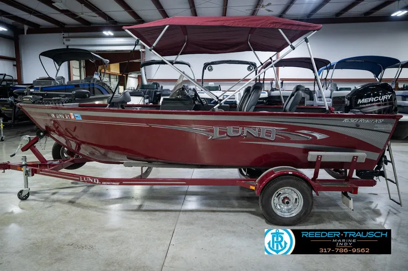 Slide: The Image of 2017 Lund 1650 Rebel XS SS boat with canopy on trailer in showroom. - 13