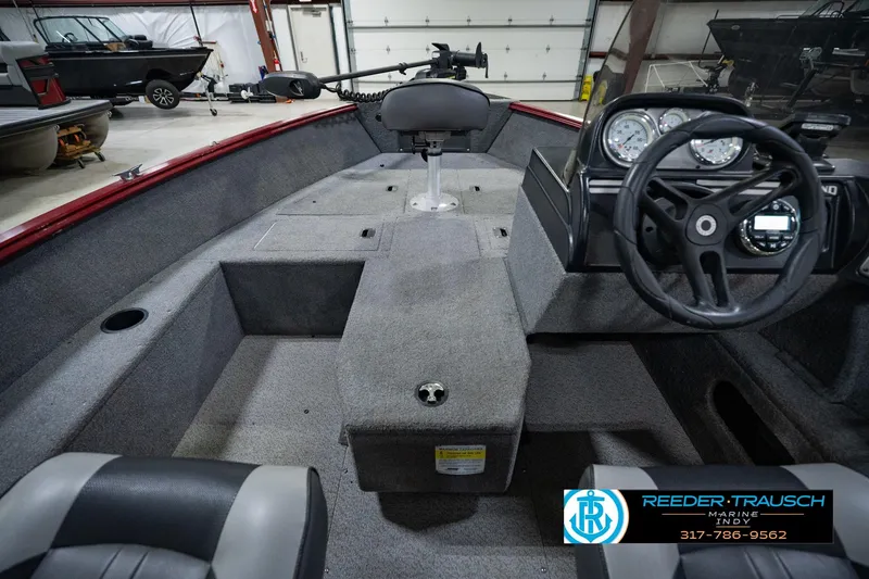 Slide: The Image of 2017 Lund 1650 Rebel XS SS boat interior with steering wheel and seating in a showroom. - 21