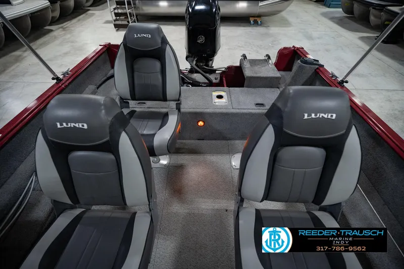Slide: The Image of 2017 Lund 1650 Rebel XS SS boat interior with gray seats and motor in showroom. - 26
