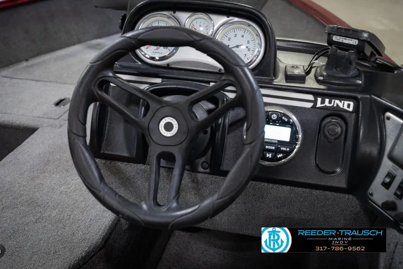 Slide: The Image of Steering wheel and dashboard of 2017 Lund 1650 Rebel XS SS boat, featuring gauges and controls. - 39