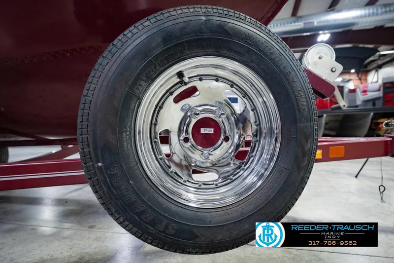 Slide: The Image of Chrome wheel of a 2017 Lund 1650 Rebel XS SS boat trailer in a showroom. - 62