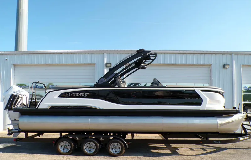 Slide: The Image of 2026 GODFREY TRITOONS SanPan 2700 pontoon boat in front of garage. - 6