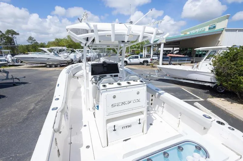 Slide: The Image of 2023 Sea Fox 288 Commander boat displayed at a dealership under a clear blue sky. - 9