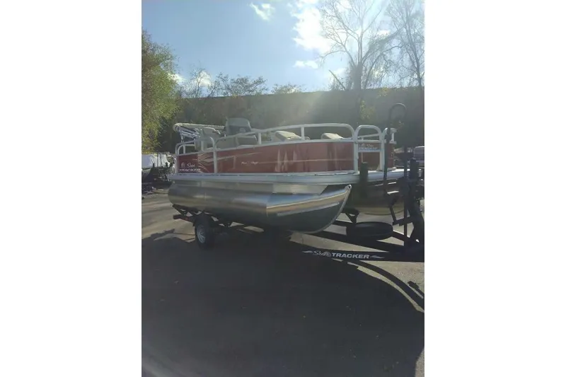 Slide: The Image of 2026 Sun Tracker Bass Buggy 16 XL Select pontoon boat on trailer, parked outdoors. - 79