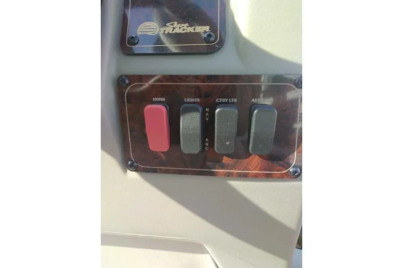 Slide: The Image of Control panel of 2026 Sun Tracker Bass Buggy 16 XL Select with switches for horn, lights, and aerator. - 82