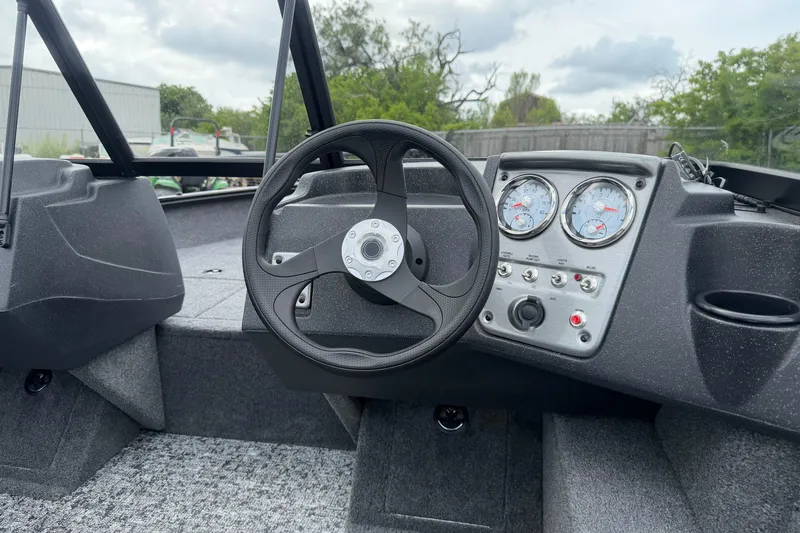 Slide: The Image of 2026 Tracker Pro Guide V-16 WT boat dashboard with steering wheel and gauges. - 54