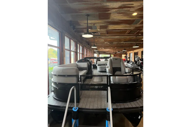 Slide: The Image of 2026 Ranger 223FC boat displayed indoors with modern seating and rustic ceiling. - 9