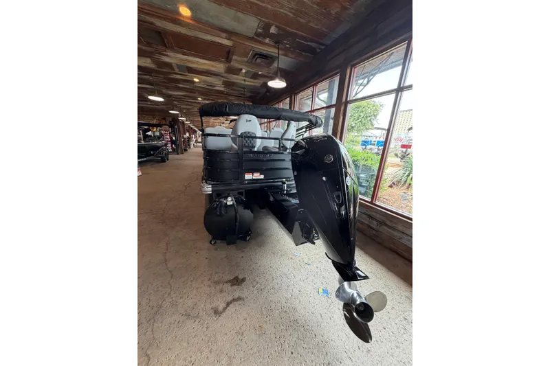 Slide: The Image of 2026 Ranger 223FC boat displayed indoors with sleek black motor and modern design. - 4