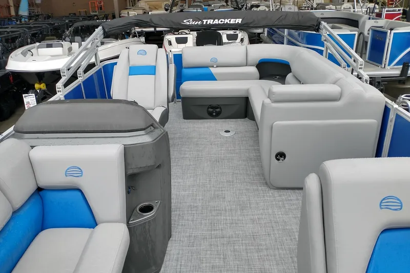 Slide: The Image of 2026 Sun Tracker Party Barge 20 DLX interior with gray and blue seating, spacious layout. - 2
