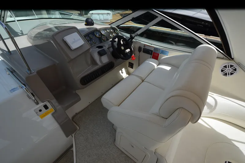 Slide: The Image of 2004 Cruisers Yachts 340 Express helm with white seating and control panel. - 13