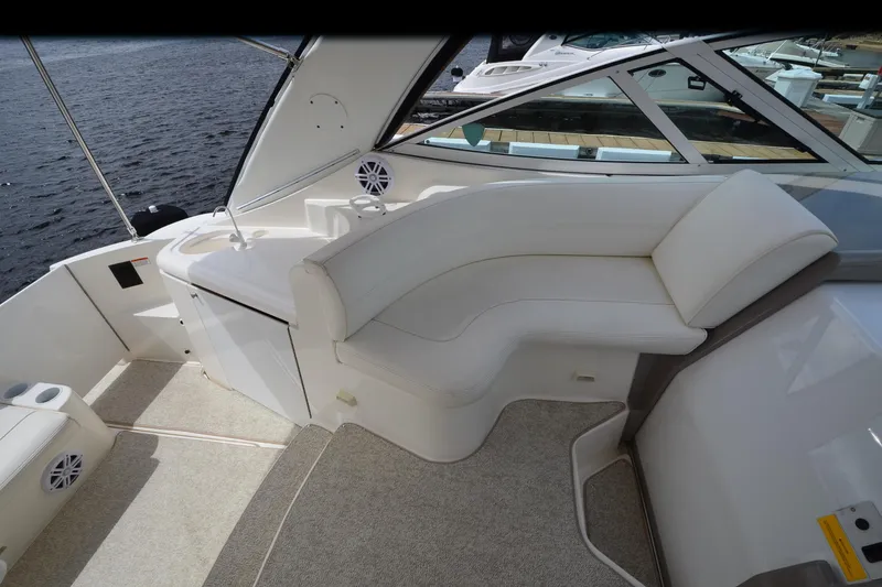 Slide: The Image of 2004 Cruisers Yachts 340 Express interior with white seating and lake view. - 15