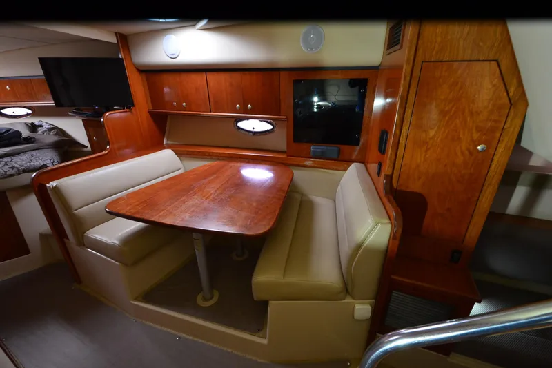 Slide: The Image of 2004 Cruisers Yachts 340 Express cabin interior with dining area and wooden cabinetry. - 21