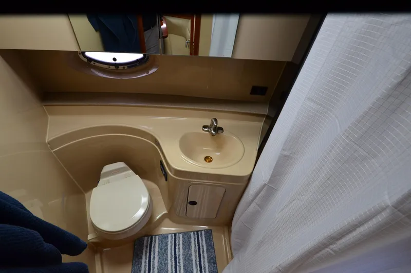 Slide: The Image of Bathroom interior of 2004 Cruisers Yachts 340 Express with toilet, sink, and shower curtain. - 30