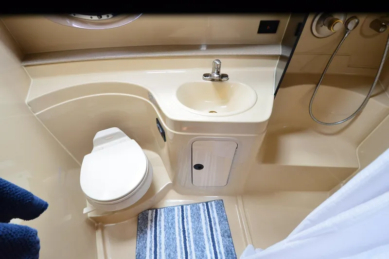 Slide: The Image of 2004 Cruisers Yachts 340 Express bathroom with toilet, sink, and shower area. - 32