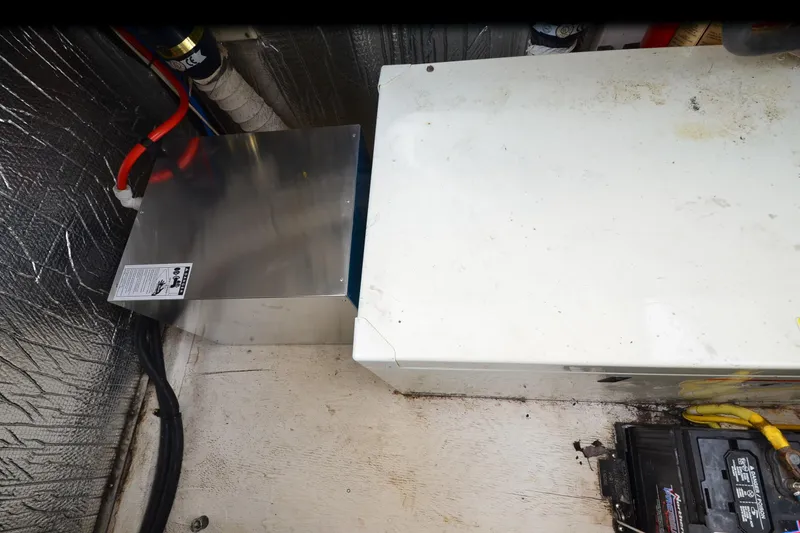 Slide: The Image of Engine compartment of a 2004 Cruisers Yachts 340 Express, featuring wiring and battery components. - 35