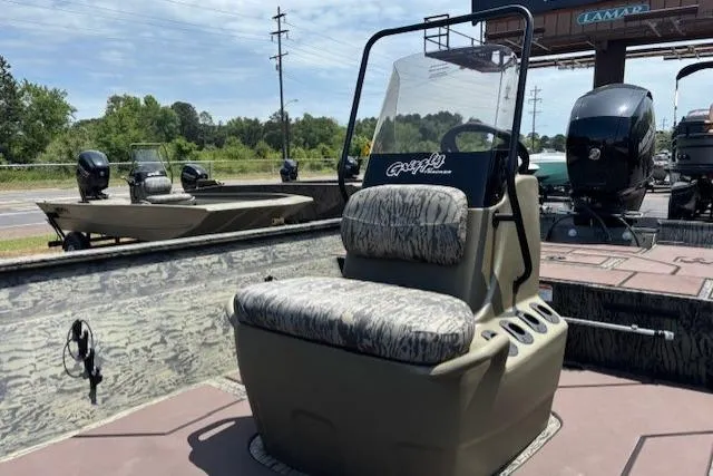 Slide: The Image of 2026 Tracker Grizzly 2072 CC boat with camo seating, displayed outdoors. - 12