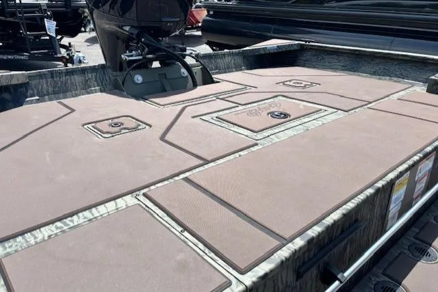 Slide: The Image of 2026 Tracker Grizzly 2072 CC boat deck with storage compartments and motor. - 14