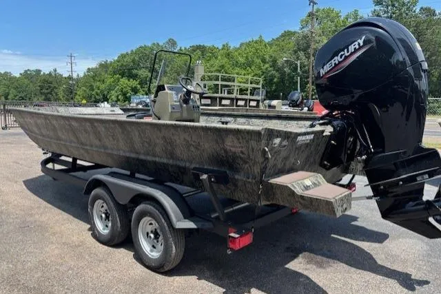 Slide: The Image of 2026 Tracker Grizzly 2072 CC boat with Mercury engine on a trailer, parked outdoors. - 3