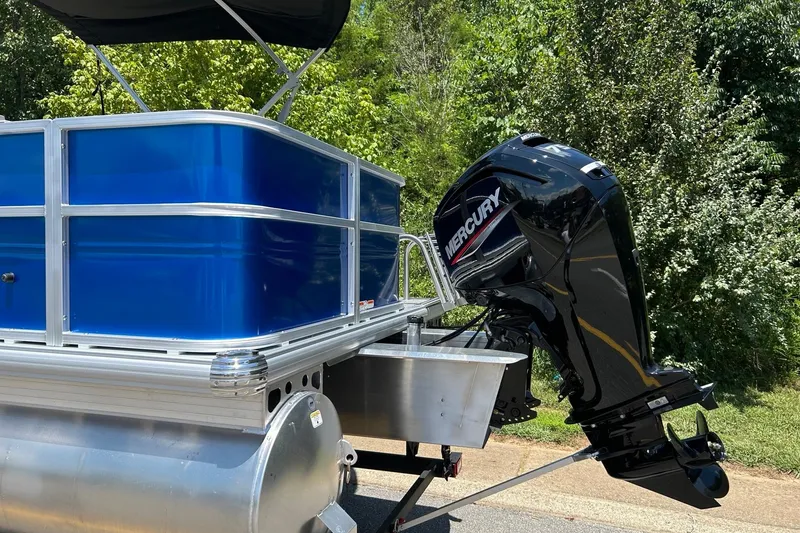 Slide: The Image of 2026 Sun Tracker Party Barge 18 DLX with Mercury outboard motor, parked outdoors. - 2
