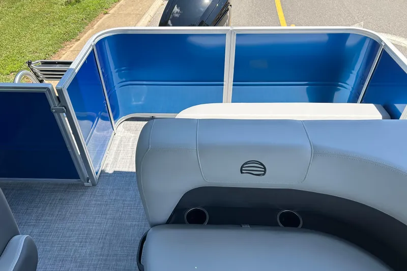 Slide: The Image of 2026 Sun Tracker Party Barge 18 DLX interior with blue panels and gray seating. - 4