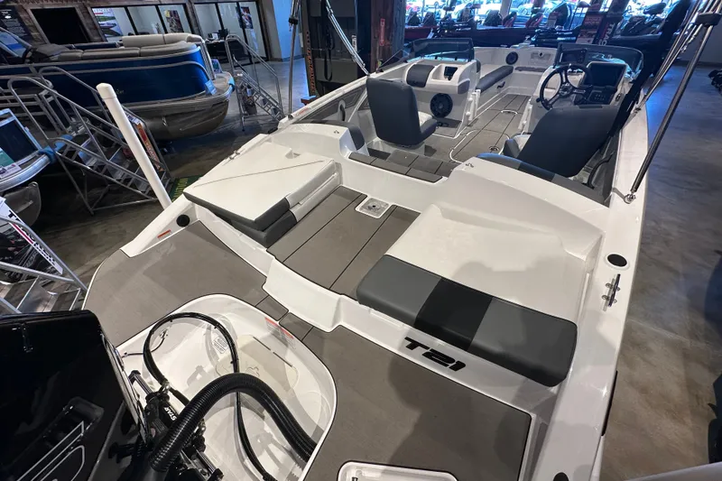 Slide: The Image of 2026 Tahoe T21 boat interior with seating and steering console in showroom. - 5