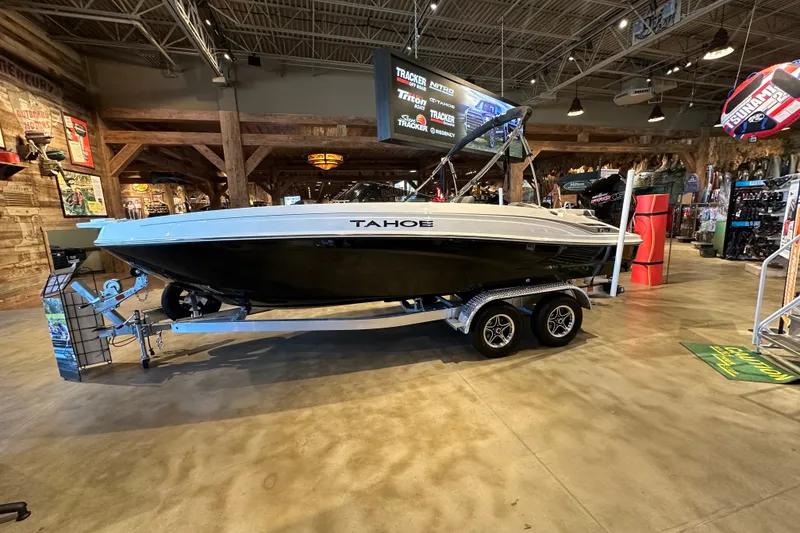 The Image of 2026 Tahoe T21 boat displayed indoors on a trailer in a showroom. - 0