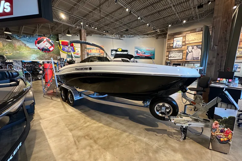 Slide: The Image of 2026 Tahoe T21 boat displayed in a showroom with promotional materials. - 1