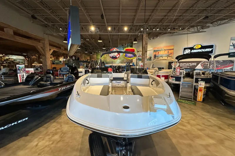 Slide: The Image of 2026 Tahoe T21 boat displayed in a showroom with various marine equipment. - 2
