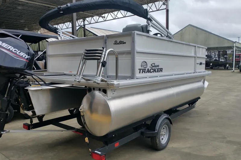 Slide: The Image of 2026 Sun Tracker Party Barge 16 DLX pontoon boat on trailer, outdoor setting. - 2