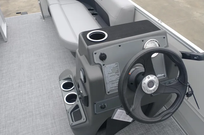 Slide: The Image of 2026 Sun Tracker Party Barge 16 DLX helm with steering wheel and cup holders. - 8