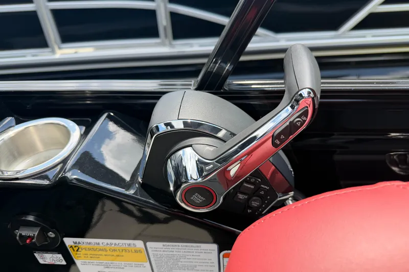 Slide: The Image of Throttle control of 2026 Regency 230 DL boat with red seating and cup holder. - 14