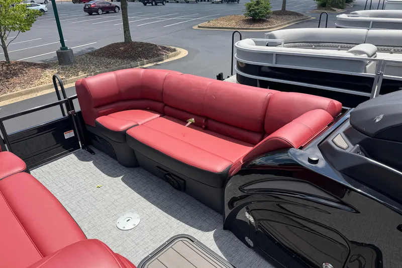 Slide: The Image of 2026 Regency 230 DL pontoon boat with red seating in a parking lot. - 8