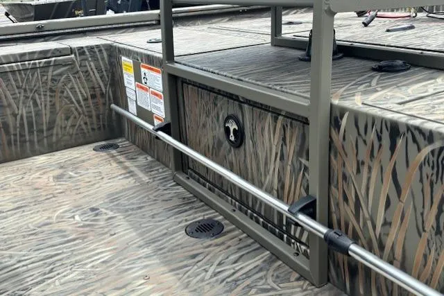 Slide: The Image of 2026 Tracker Grizzly 2072 CC Sportsman Kicker boat interior with camouflage design and safety labels. - 20