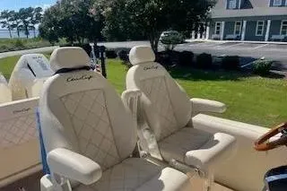Slide: The Image of 2024 Chris-Craft Catalina 30 boat seats with elegant diamond stitching, parked outdoors. - 20