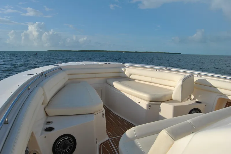 Slide: The Image of 2018 Grady-White Canyon 376 boat interior with cushioned seating, ocean view, and clear sky. - 7