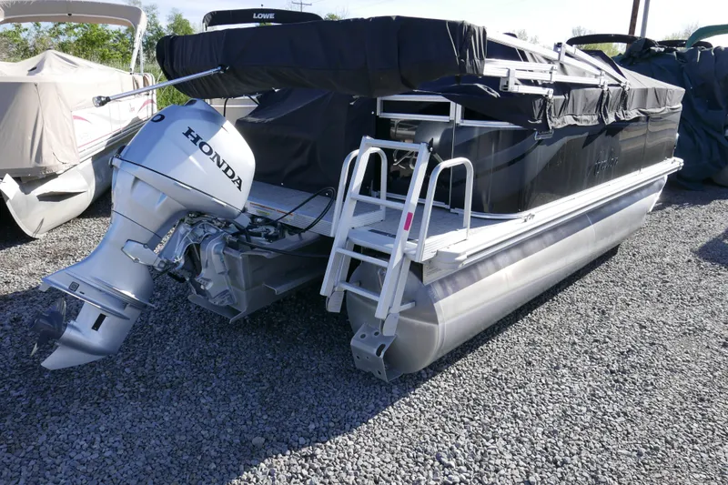 Slide: The Image of 2024 Avalon Venture Bow Fish 1575 pontoon boat with Honda outboard motor on gravel. - 14
