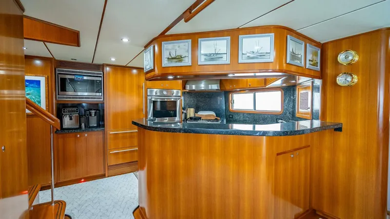 Slide: The Image of Luxurious 2009 Nordhavn 76 yacht interior with elegant wood cabinetry and modern kitchen appliances. - 16