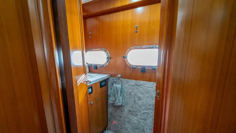 Slide: The Image of Luxurious bathroom interior of 2009 Nordhavn 76 yacht with wooden finish and porthole windows. - 23