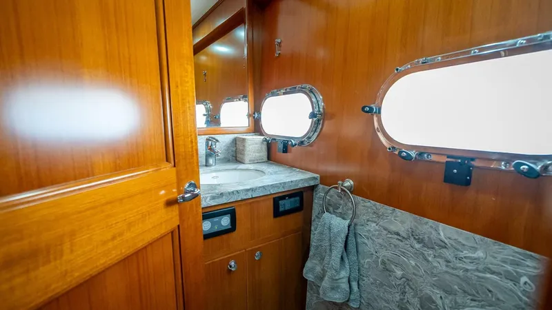 Slide: The Image of Luxurious bathroom interior of 2009 Nordhavn 76 yacht with wooden cabinetry and porthole windows. - 24