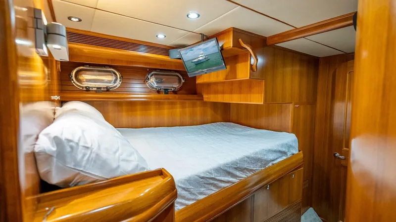Slide: The Image of Luxurious cabin interior of 2009 Nordhavn 76 yacht with wood paneling and cozy bed. - 25