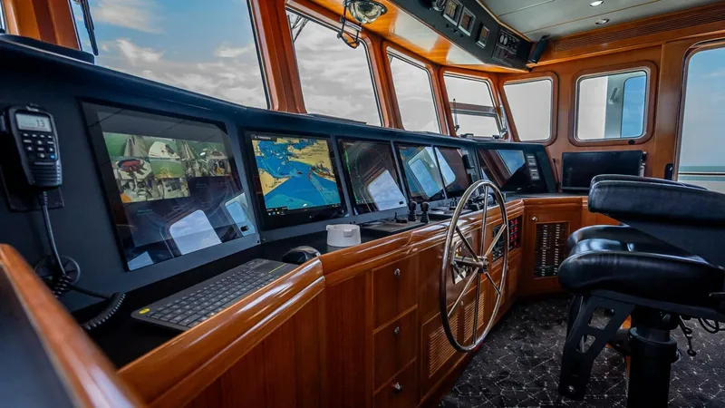 Slide: The Image of Pilothouse of 2009 Nordhavn 76 yacht with navigation screens and steering wheel. - 42