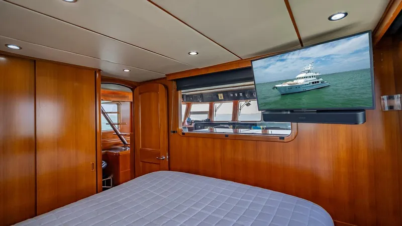 Slide: The Image of Luxurious cabin interior of 2009 Nordhavn 76 yacht with wood paneling and mounted TV. - 48