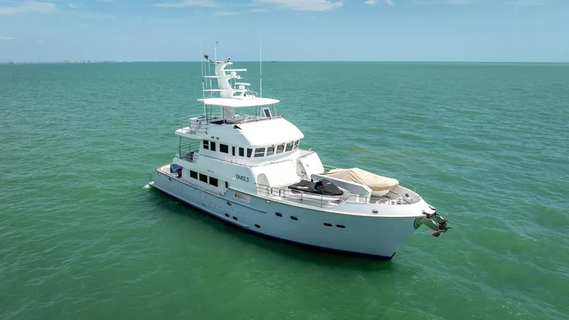 Slide: The Image of Luxurious 2009 Nordhavn 76 yacht cruising on calm, turquoise waters under a clear sky. - 7