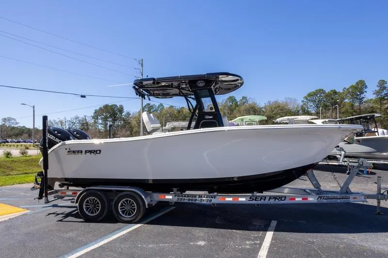 Slide: The Image of 2025 Sea Pro 262 Offshore boat on trailer, parked outdoors under clear sky. - 12
