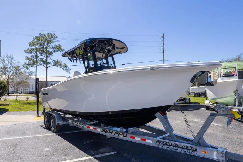 Slide: The Image of 2025 Sea Pro 262 Offshore boat on trailer, parked outdoors under clear blue sky. - 13