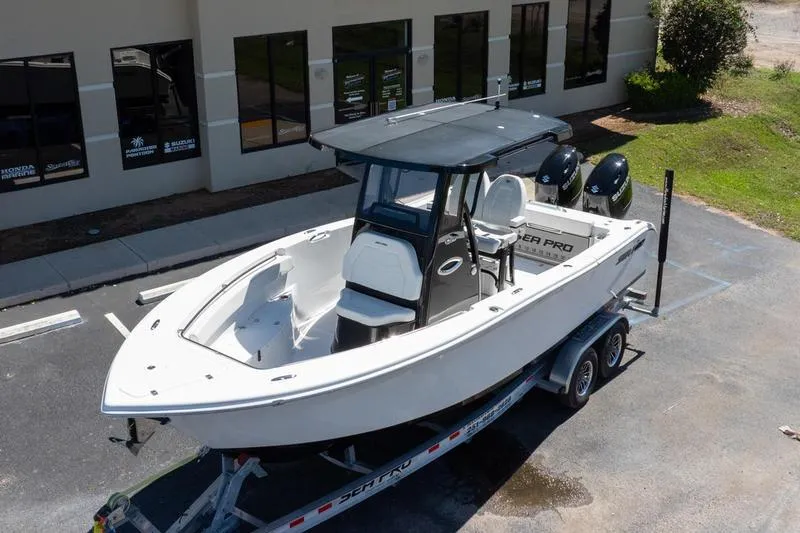 Slide: The Image of 2025 Sea Pro 262 Offshore boat on trailer, parked outside a building. - 2